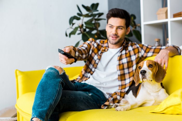 hombre con perro en el sofá