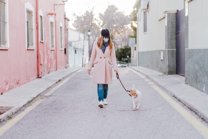 mujer pasea con perro por la calle
