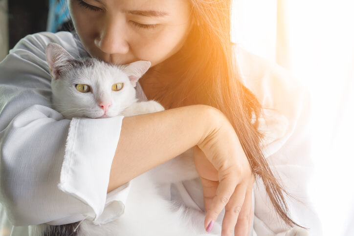 mujer besa a gato